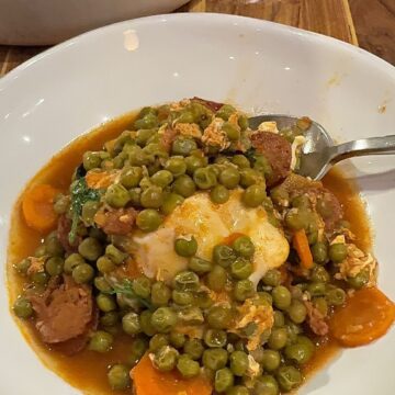 Ervilhas Guisadas in a bowl with a spoon sticking out.