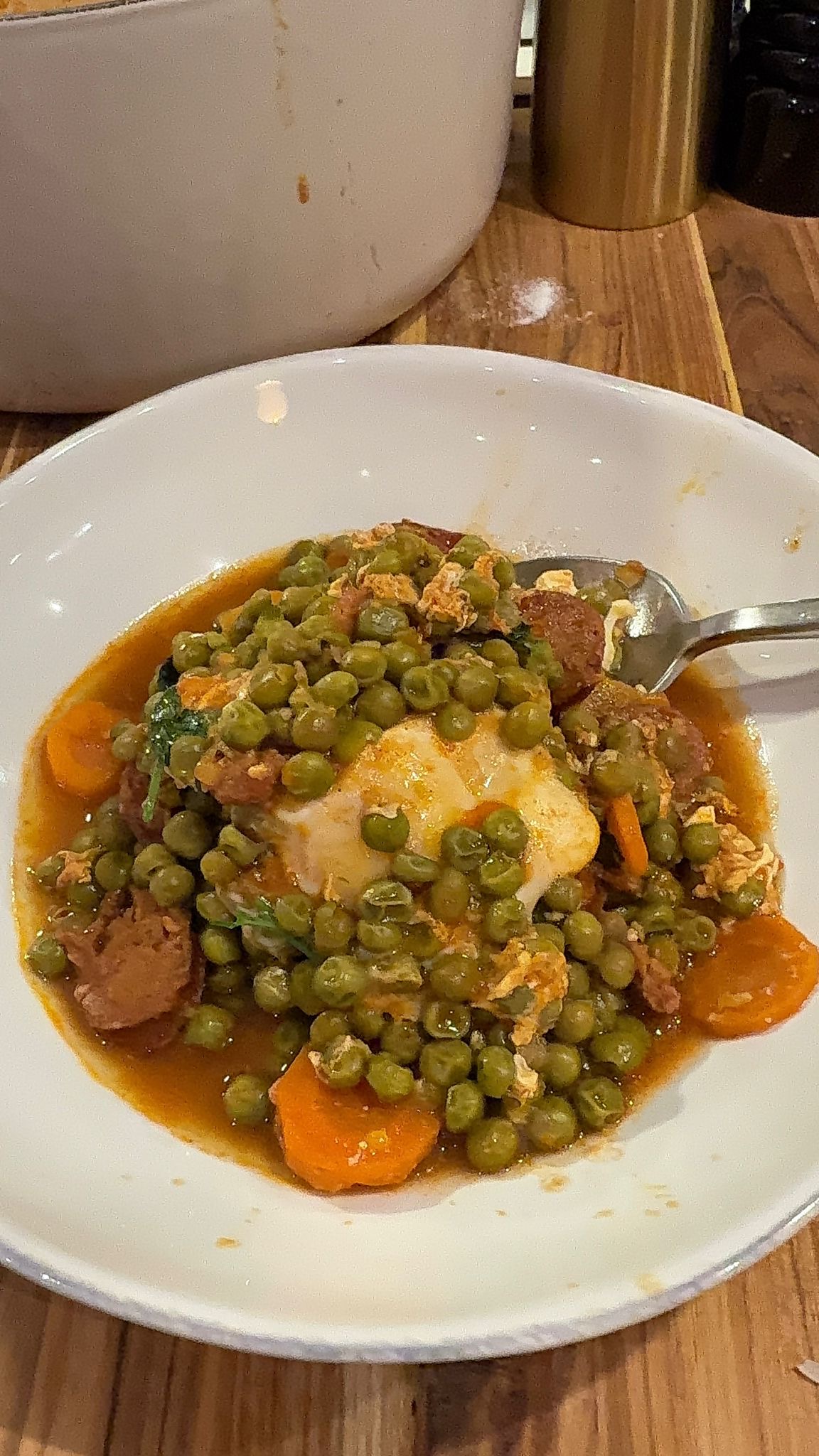 Ervilhas Guisadas in a bowl with a spoon sticking out. 